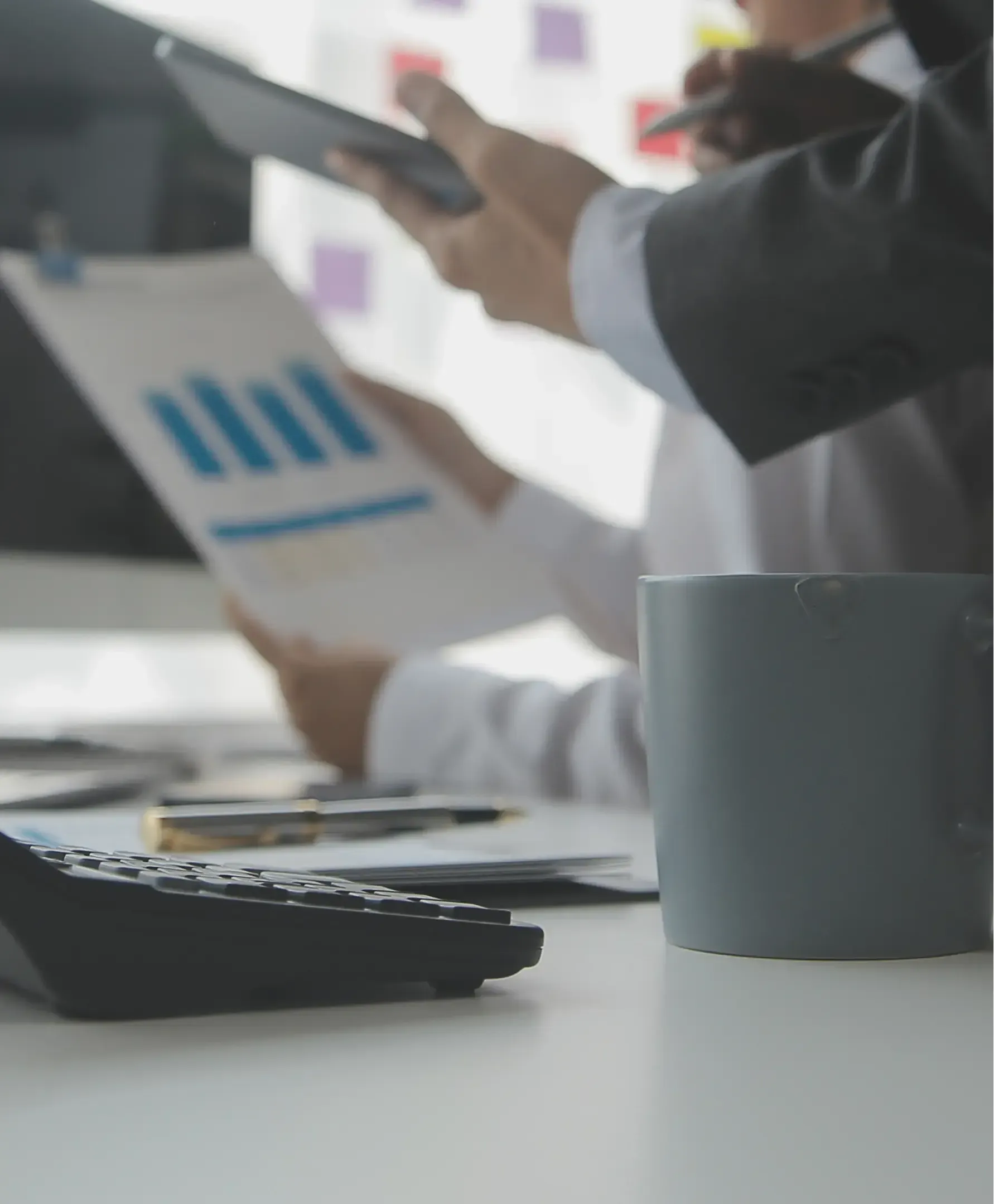 Calculator on desk with people talking in background